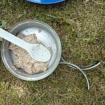 Mixing up the flatbread dough in a pot with a camp spoon.