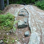 At a culturally important site, a crack formation on a rock resembles the shape of a canoe.