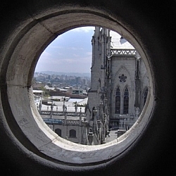 View of Quito through a round window of the Basilica del Voto Nacional.