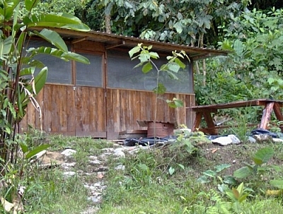 The kitchen building at Merazonia, with a wooden picnic table outside.