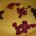 An assortment of dehydrated berries stacked on a yellow plate