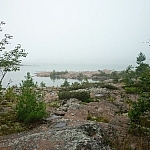 A rocky pink granite shoreline along a foggy Georgian Bay.