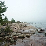 A rocky Georgian Bay coastline hugged by equally grey skies and waters.