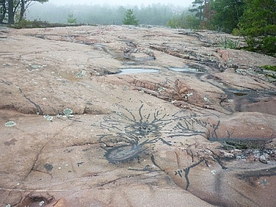 Interested patterns splattered onto the rock surface with tar.