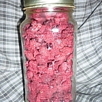 Jar of dehydrated raspberries against a blue plaid background