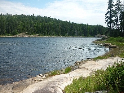 Rocky shores along a lake while day hiking Hawk Ridge Trail at Halfway Lake Provincial Park.