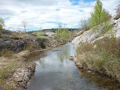 Beautiful scenery of a stream dumping seemingly into the sky while trekking Killarney's La Cloche Silhouette loop trail.