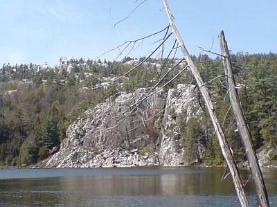 This photograph of Killarney Provincial Park was taken on the day hike which inspired the March for Merazonia. A white quartzite cliff face rises over a smooth-surfaced lake in Killarney Provincial Park.