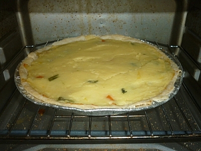Vegetarian pie baking with mixed vegetables and mashed potatoes.