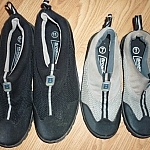 A black pair of men's water shoes, and a grey pair for women