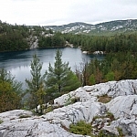 A beautiful lake surrounded by mountains, the typical scenery of trekking Killarney's La Cloche Silhouette loop trail.