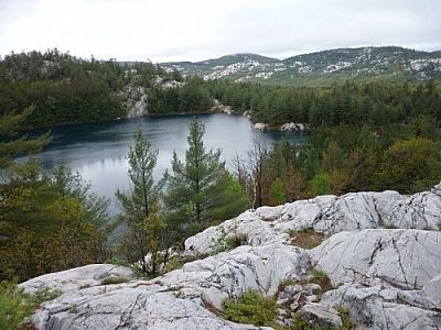 Landscape of lakes and white quartzite mountains seen while hiking the La Cloche Silhouette Trail