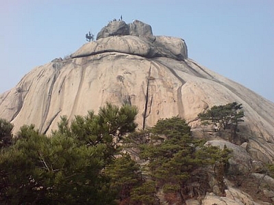 Watching people take a steep path down a hill from a safe distance along the official trail.