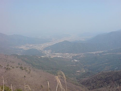 A city nestled between mountains seen while hiking at Gajisan Provincial Park.