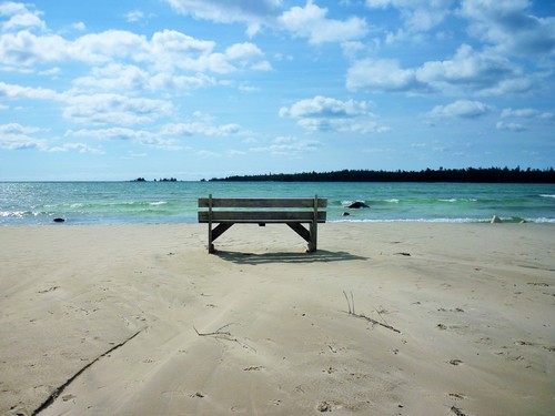 A bench on a sandy beach overlooks Misery Bay.